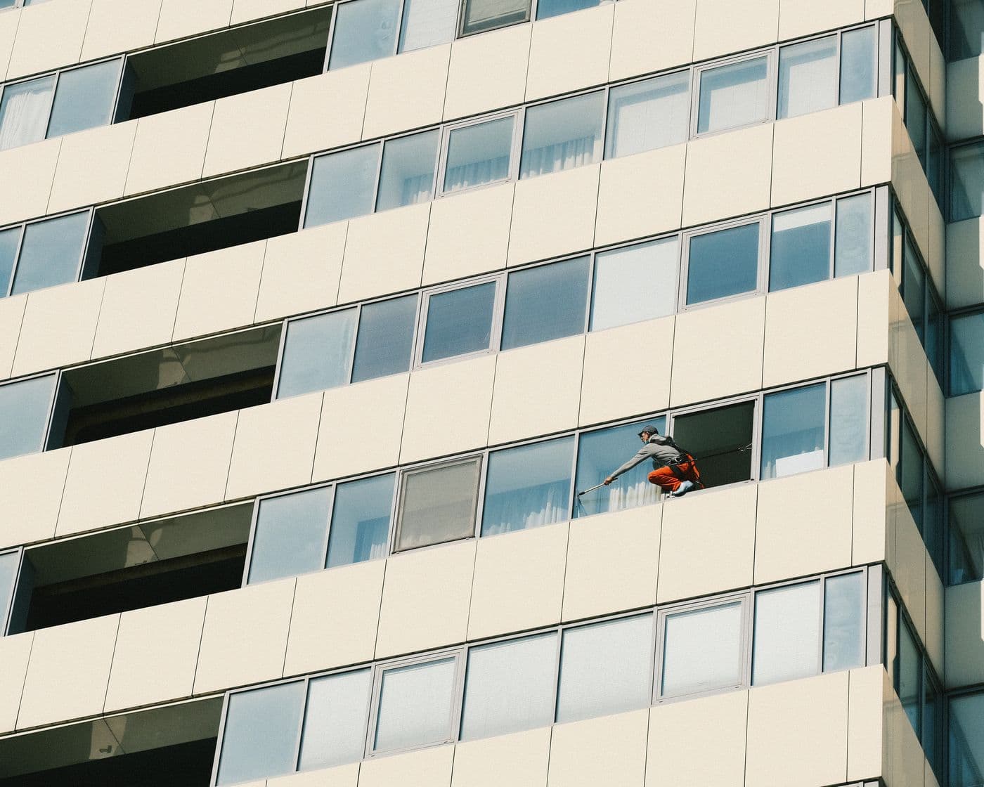 Fensterreiniger arbeitet an der Glasfassade eines Hochhauses