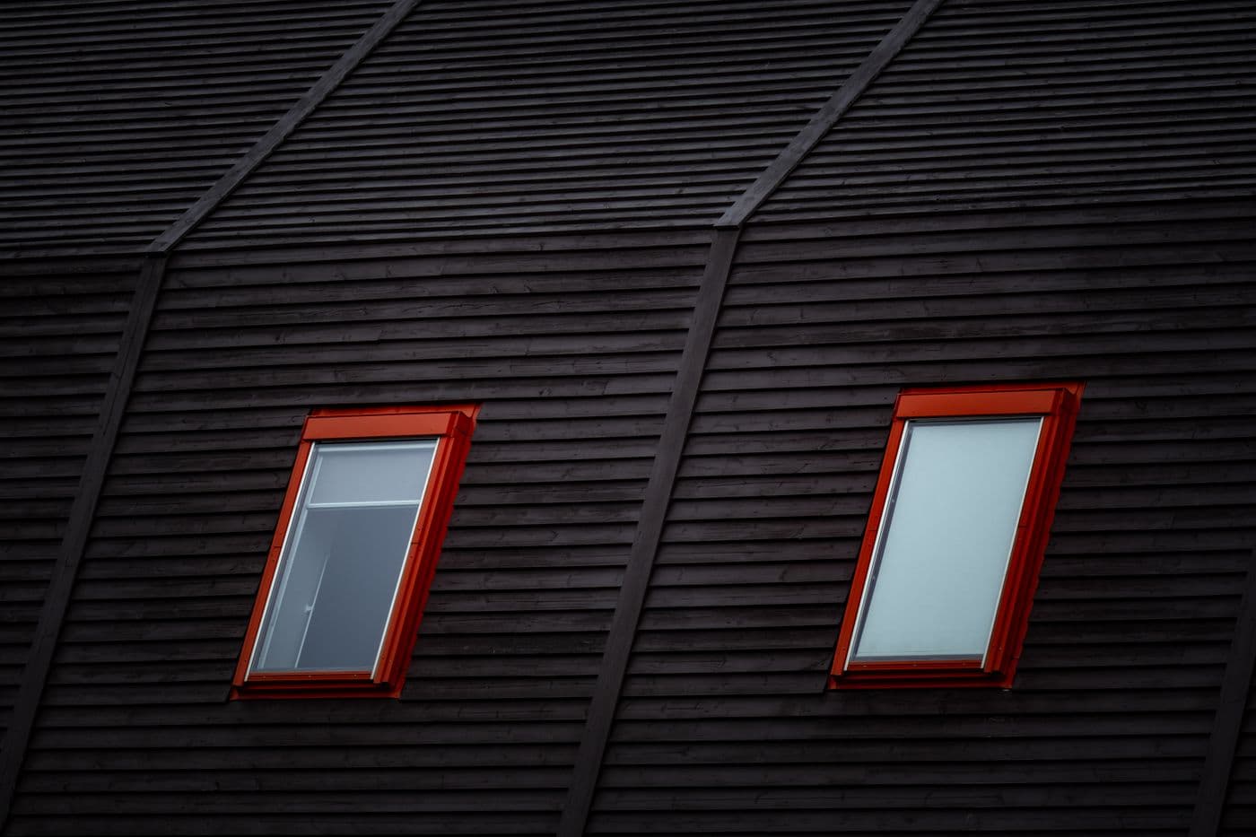 Zwei Dachfenster in einer Holzfassade