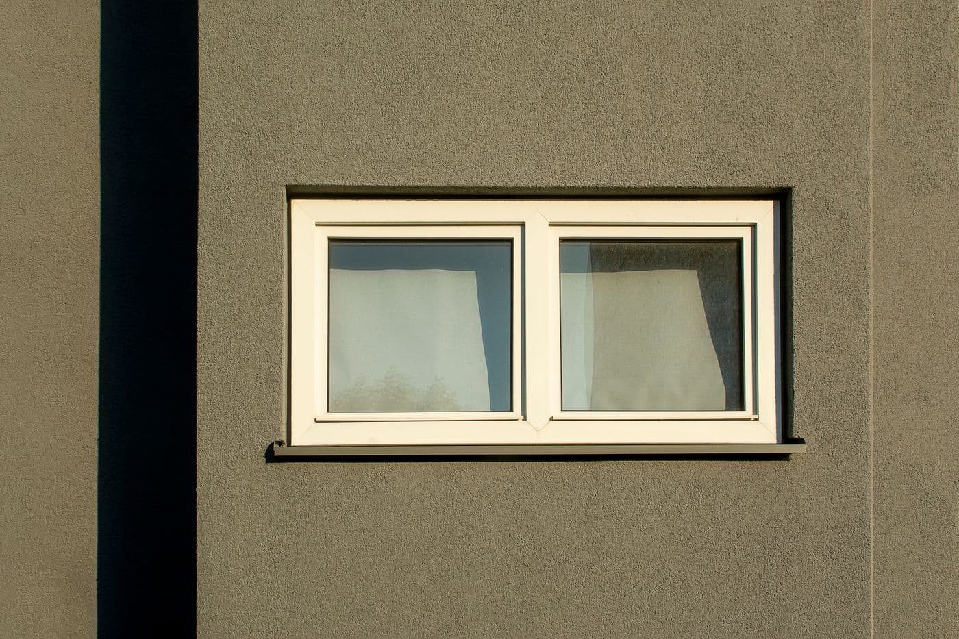 Schlichtes zweiflügliges Fenster in heller Fassade