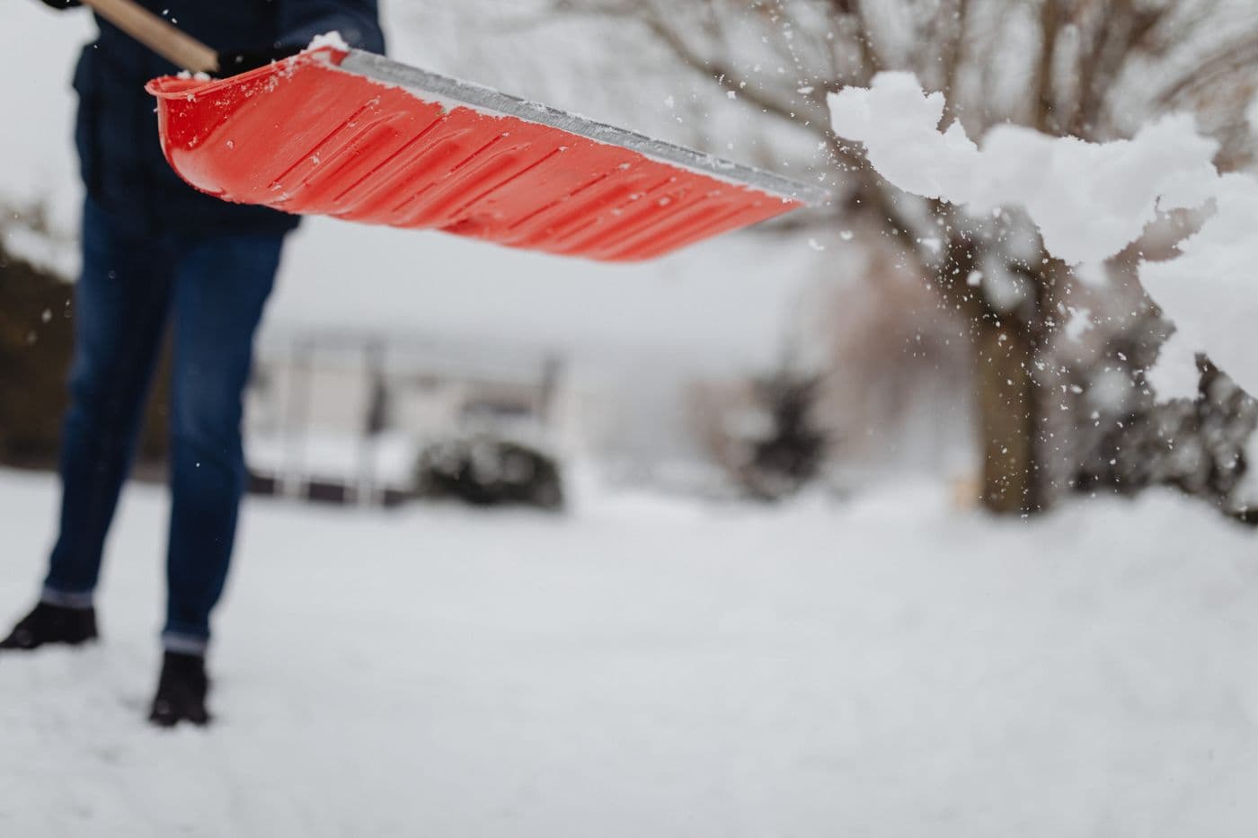 Schneeschaufel räumt frischen Schnee von einem Weg